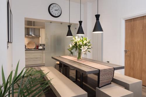 a dining room with a table and a clock on the wall at Number 19 Chapel Court in Leamington Spa