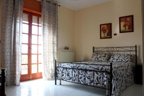 a bedroom with a bed and a sliding glass door at La casa di Bia in Corleone