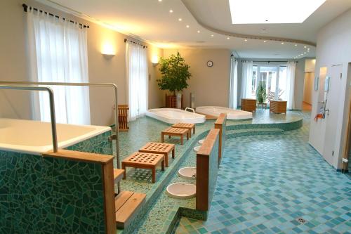 a bathroom with two sinks and a tub and benches at Hotel Deutscher Hof in Trier