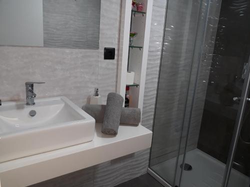 a white bathroom with a sink and a shower at Next to the Airport in Moreira