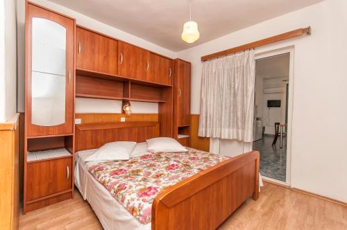 a bedroom with a bed with a wooden headboard at Guest house Mediteran Relax in Makarska