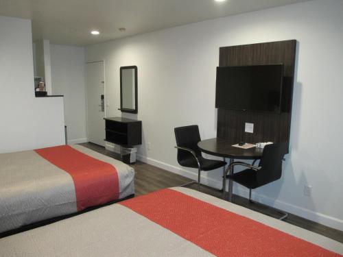 een hotelkamer met een bed, een tafel en een televisie bij Claremont Lodge in Claremont