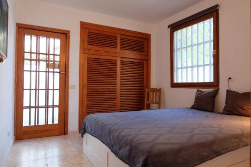 a bedroom with a large bed and two windows at Chalet Lobo in Poris de Abona