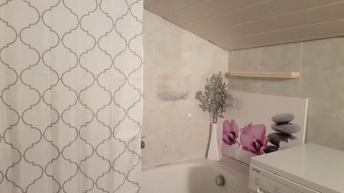 a bathroom with a bath tub with a vase of flowers at Amazing View Pirano in Piran