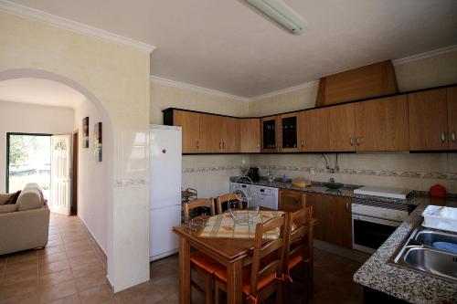 a kitchen with a table and a dining room at Monte Belo Romão in Olhão