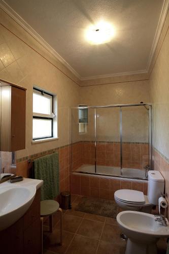 a bathroom with a tub and a toilet and a sink at Monte Belo Romão in Olhão