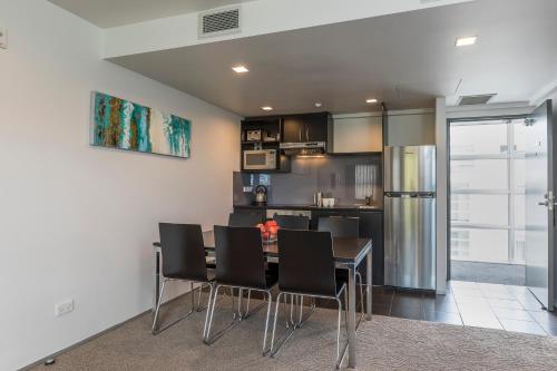 a kitchen and dining room with a table and chairs at Quest Ponsonby Serviced Apartments in Auckland