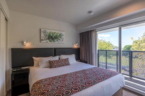 a bedroom with a bed and a large window at Quest Ponsonby Serviced Apartments in Auckland