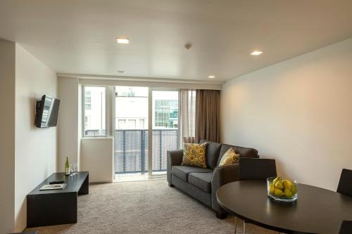a living room with a couch and a table at Quest Ponsonby Serviced Apartments in Auckland