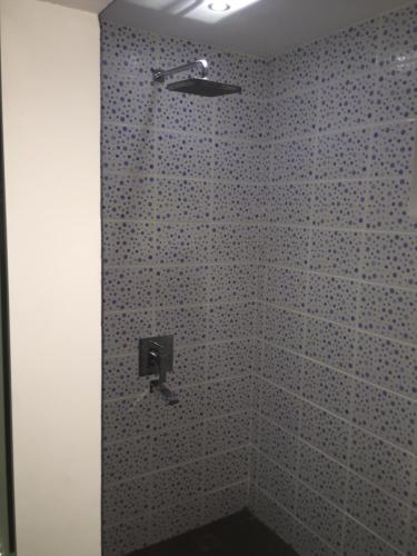 a bathroom with a shower with a tiled wall at Cabilao Sunset Dive & Beach Resort in Loon