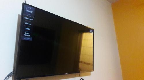 TV de pantalla plana colgada en la pared en Cáyamahue Guest House, en Pucallpa