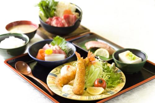 a tray with a plate of food and bowls of food at The Kato Hotel in Tokai