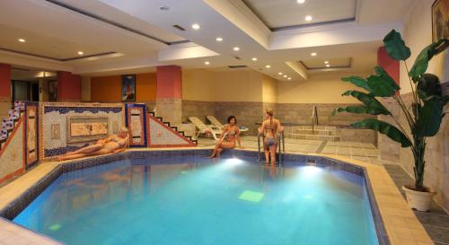 a group of people sitting around a swimming pool at Seagull Hotel in Beldibi