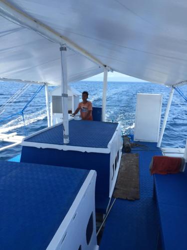 a man sitting on a boat in the ocean at Cabilao Sunset Dive & Beach Resort in Loon