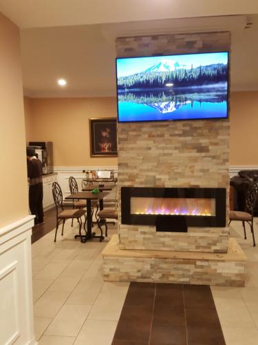a living room with a fireplace with a tv above it at Midway Motel in Brandon