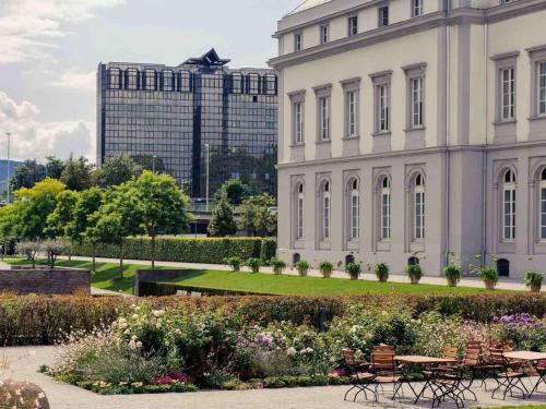 a building with tables and chairs in front of it at Mercure Hotel Koblenz in Koblenz