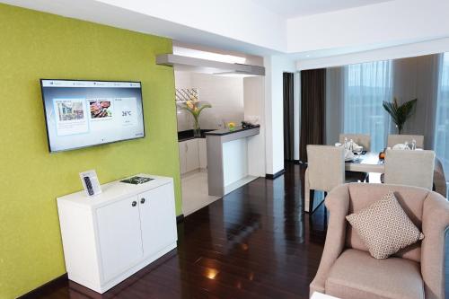a living room with a tv on a green wall at Platinum Adisucipto Hotel & Conference Center in Yogyakarta