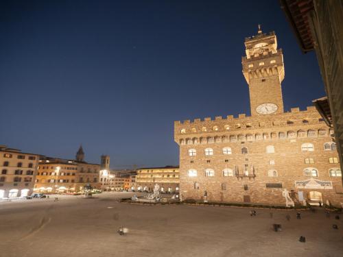 a large building with a clock tower at night at Relais Uffizi in Florence