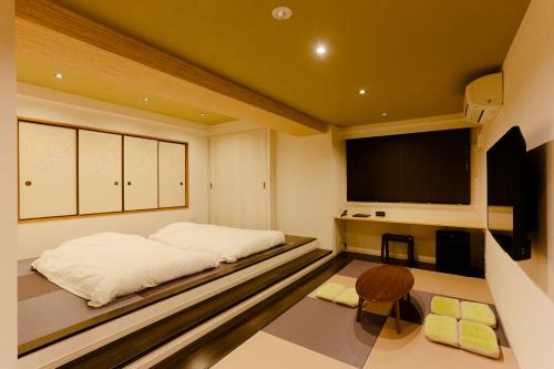 a room with two beds and a flat screen tv at Ueno First City Hotel in Tokyo