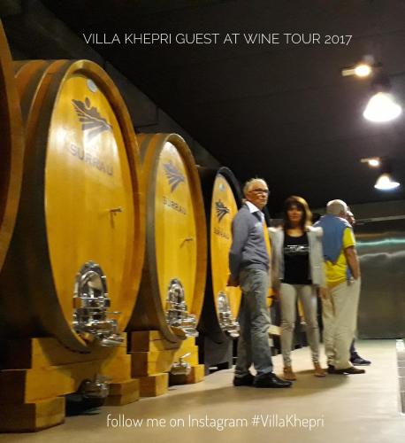 a group of people standing in front of wine barrels at Villa Khepri in Porto Rotondo