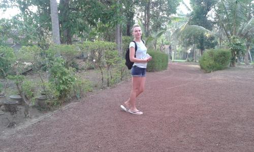 a woman with a backpack standing in a park at Sunset Villa in Negombo