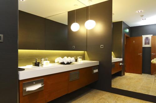 łazienka z 2 umywalkami i dużym lustrem w obiekcie Mikado Hotel w mieście Nitra