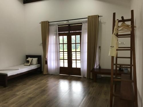 錫吉里亞的住宿－Into The Wild Sigiriya，一间设有床、梯子和窗户的房间