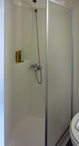 une douche avec une porte vitrée dans une salle de bain dans l'établissement Hôtel Noctuel Blois Sud, à Saint-Gervais-la-Forêt