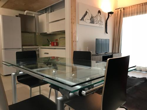 a kitchen with a glass dining table and chairs at Residenza Bolognino in Granarolo dellʼEmilia