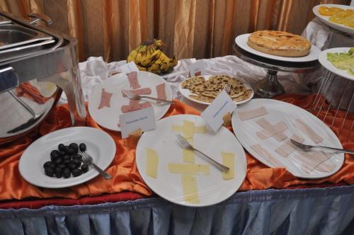 a table topped with plates and utensils and food at Kaleb Hotel in Addis Ababa