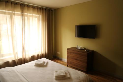 a bedroom with a bed and a television on the wall at Hygge in Tatariv