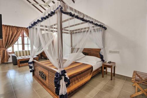 a bedroom with a canopy bed with white curtains at Dambulla Hills Resort in Dambulla