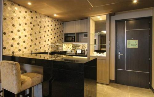 セブシティにあるbai Hotel Cebuのキッチン(黒いカウンター付)、バー(椅子付)