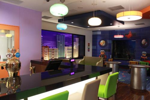 a bar in a restaurant with neon green chairs at LEGOLAND Japan Hotel in Nagoya
