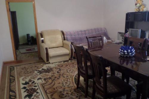 Una sala de estar con una mesa y sillas y un sofá. en Spandaryan House, en Yeghegnadzor