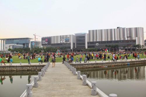 a group of people walking along a pier near a body of water at De Houz @ Setia Alam Trefoil Homestay in Shah Alam