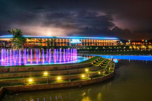 a building with a fountain in the water at night at De Houz @ Setia Alam Trefoil Homestay in Shah Alam
