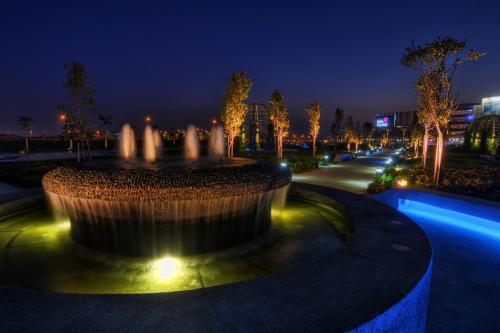 a fountain with lights in a park at night at De Houz @ Setia Alam Trefoil Homestay in Shah Alam