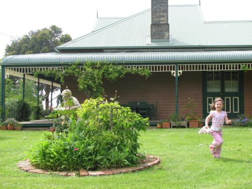 a little girl running in front of a house at Butterfly Farm Bed and Breakfast Nirranda in Nirranda