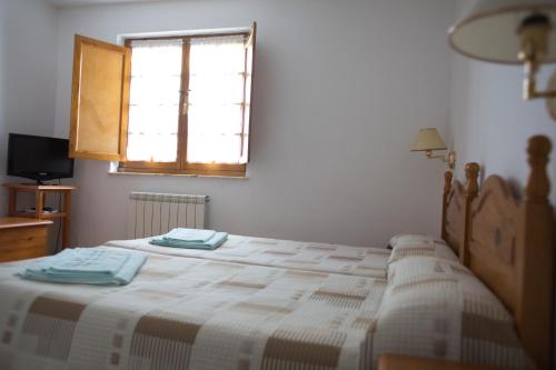 sypialnia z 2 łóżkami i oknem w obiekcie Casa Rural La Fueya w mieście Oviñana