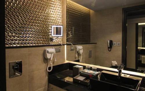 a bathroom with a sink and a mirror at bai Hotel Cebu in Cebu City