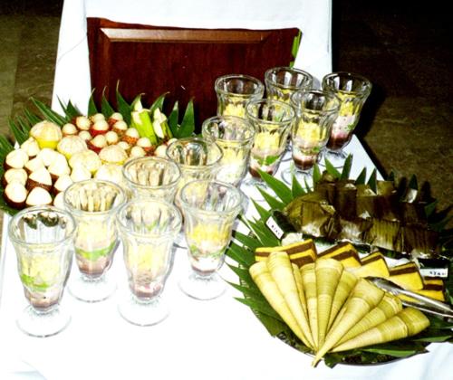 a table with wine glasses and a plate of fruit at Imaj Private Villas in Senggigi 