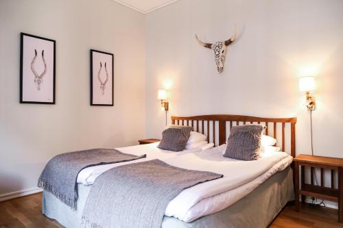 a bedroom with a large white bed with two pillows at Hotel Kärnan in Helsingborg