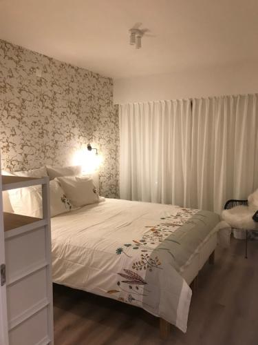 デ・パンネにあるWellington F4の花柄の壁紙を用いた白いベッドが備わるベッドルーム1室