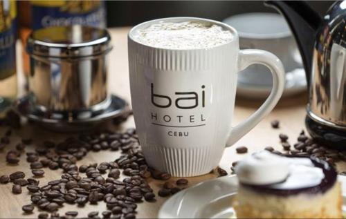a cup of coffee and a doughnut on a table at bai Hotel Cebu in Cebu City