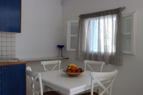 a bowl of fruit on a white table in a kitchen at Grand Bleu Apartments & Villas in Ermioni
