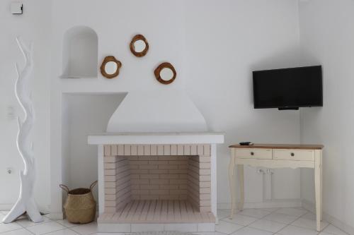 a living room with a fireplace and a tv at Grand Bleu Apartments & Villas in Ermioni