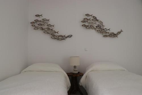 two beds on a white wall with hearts on the wall at Grand Bleu Apartments & Villas in Ermioni