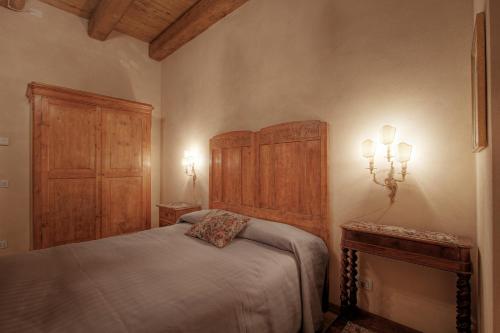 a bedroom with a bed and a wooden headboard at La Fornasaccia in Cesena