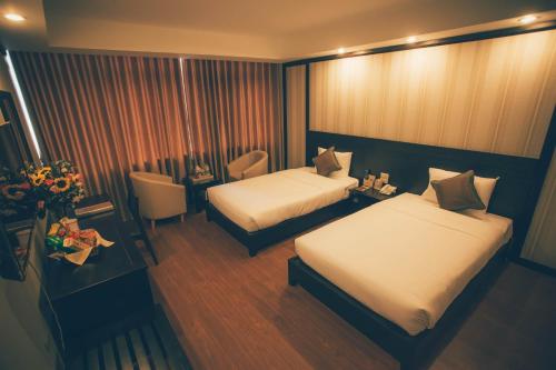 a small hotel room with two beds and a table at Friendship hotel in Hanoi